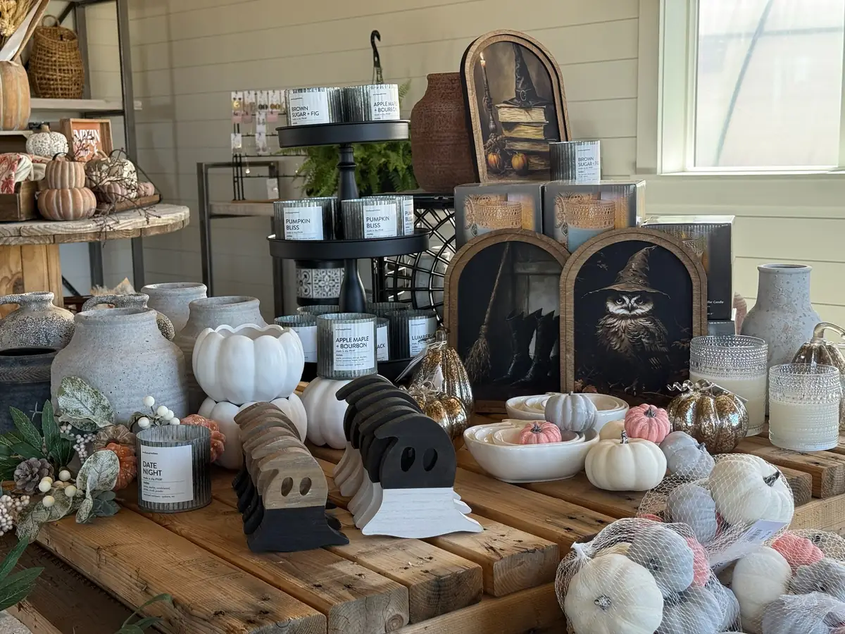 Fall décor in the boutique: white pumpkins, candles and owl art on a rustic wooden table