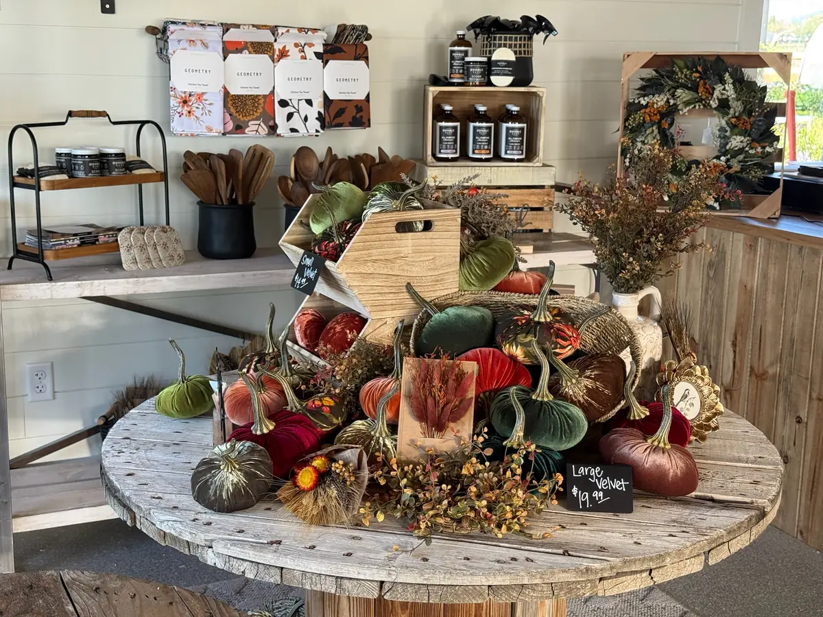 A round spool table piled with velvet pumpkins and fall accents in the boutique
