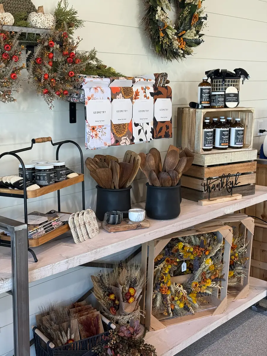 Boutique shelves with wreaths, wooden spoons, candles and dried florals